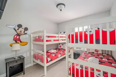 a bedroom with two bunk beds and a mickey mouse bedroom at Elegant Townhome with Water View in Kissimmee