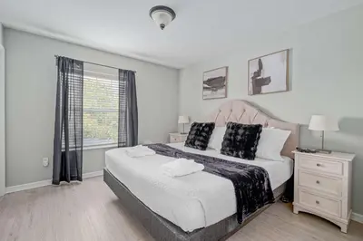 a bedroom with a large bed and a window at Elegant Townhome with Water View in Kissimmee