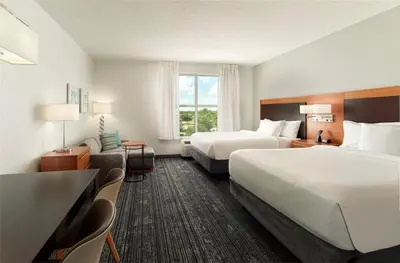 a hotel room with two beds and a window at TownePlace Suites Orlando at FLAMINGO CROSSINGS Town Center, Western Entrance in Orlando