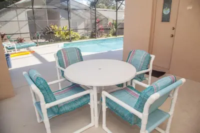 a white table and chairs next to a pool at Rocco's Retreat in Orlando