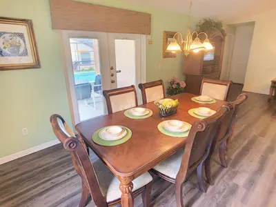 a dining room with a wooden table and chairs at Rocco's Retreat in Orlando