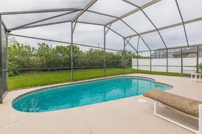 a swimming pool under a metal roof with a swimming poolvisor at Safari Lodge in Orlando