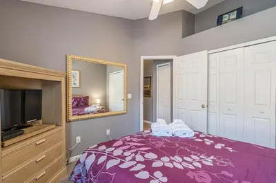 a bedroom with a purple bed and a mirror at Pool Paradise in Orlando