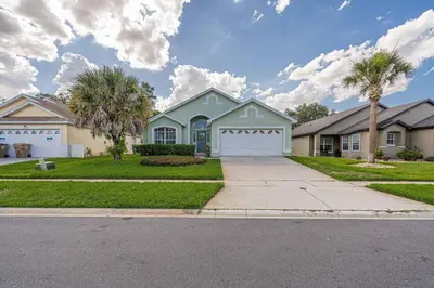 a house with a palm tree and a driveway at Pool Paradise in Orlando