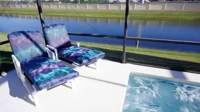 two chairs sitting on a porch next to a swimming pool at Minnie's Marvel in Kissimmee