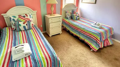 a bedroom with two beds and a dresser in it at Minnie's Marvel in Kissimmee
