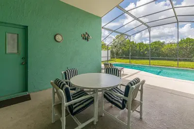 a dining room with a table and chairs and a pool at The Boat House in Orlando