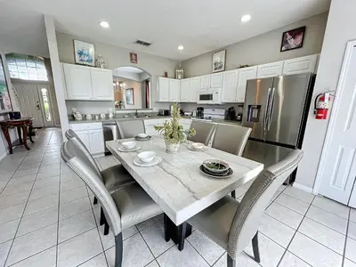 a kitchen with a table and chairs and a refrigerator at Island Paradise in Kissimmee