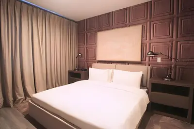 a bedroom with a large bed with white sheets at Casa Luxo 4 Suítes no Magic Village in Kissimmee