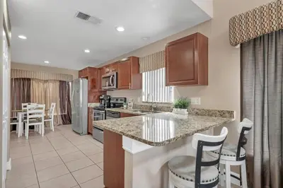a kitchen with a counter and chairs in a room at Lakefront Home with Game Room and Views in Kissimmee