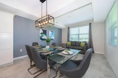 a dining room and living room with a table and chairs at Condo in the Heart of Orlando - 10 Min from Disney in Kissimmee