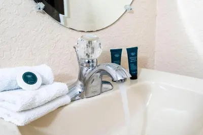 a bathroom sink with a faucet and towels on it at Central House Near Disney in Orlando