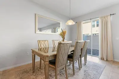 a dining room with a table and chairs and a mirror at Casa 4Q perto da Disney + Piscina no Clube in Kissimmee