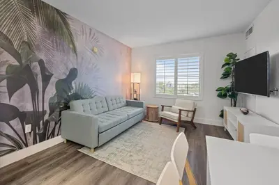 a living room with a couch and a flat screen tv at King suite near Epic & Universal, free parking in Orlando