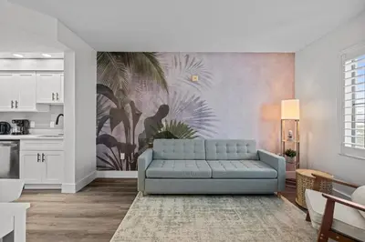 a living room with a blue couch and a kitchen at King suite near Epic & Universal, free parking in Orlando