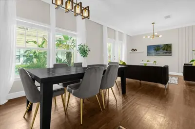 a dining room with a black table and chairs at Casa 4Q c/ Piscina e Padaria – Perto da Disney in Kissimmee