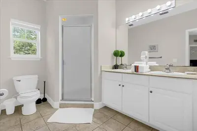 a white bathroom with a toilet and a sink at Casa 4Q c/ Piscina e Padaria – Perto da Disney in Kissimmee