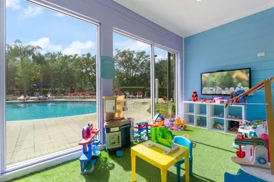 a childs play room with a pool and a sliding glass door at Casa 4Q c/ Piscina e Padaria – Perto da Disney in Kissimmee