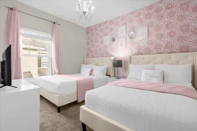 a bedroom with two beds and a chandelier at Casa 4Q c/ Piscina e Padaria – Perto da Disney in Kissimmee