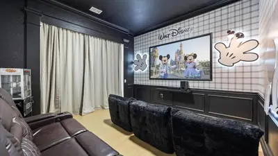 a movie room with a couch and a screen at Upstay Newly Renovated Family Retreat Home Near Epic Universe in Orlando