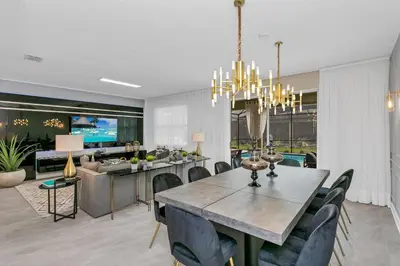 a dining room with a table and a kitchen at Huge 9-Bedroom Luxury Villa Near Disney With Pool in Kissimmee