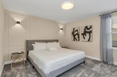 a bedroom with a white bed and a window at Huge 9-Bedroom Luxury Villa Near Disney With Pool in Kissimmee