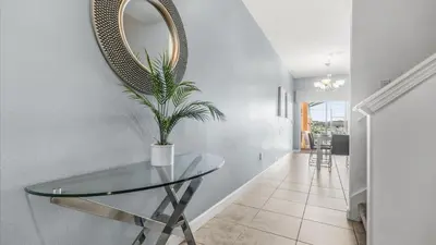 a dining room with a glass table and a mirror at Family Resort Getaway w Pool & Patio near Disney in Kissimmee