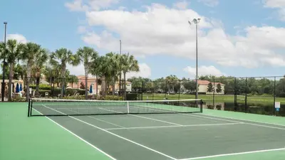a tennis court with a tennis net on it at Family Resort Getaway w Pool & Patio near Disney in Kissimmee