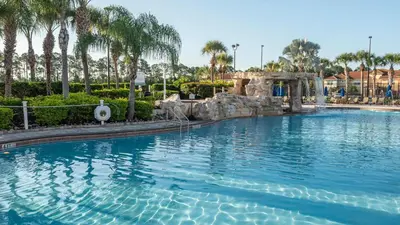 a large swimming pool in a resort with palm trees at Family Resort Getaway w Pool & Patio near Disney in Kissimmee