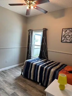 a bedroom with a bed and a window at Orlando Lakefront Pool Villa 25 min Disney & Univ in Orlando