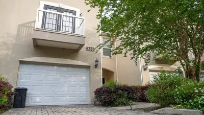 a house with a garage and a building with a window at Stylish and cozy townhome! in Orlando