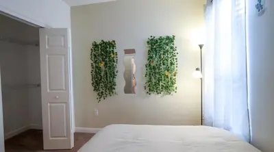 a bedroom with a bed and some green plants on the wall at Stylish and cozy townhome! in Orlando