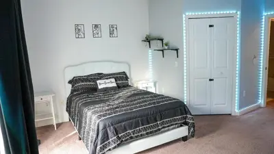 a white bedroom with a bed and a mirror at Stylish and cozy townhome! in Orlando