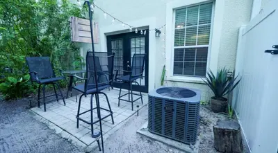 a patio with chairs and a table and a heater at Stylish and cozy townhome! in Orlando