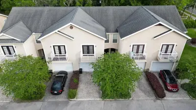 a house with two cars parked in front of it at Stylish and cozy townhome! in Orlando