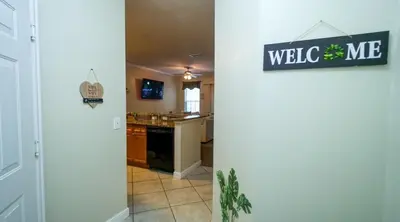 a kitchen with a welcome sign on a wall at Stylish and cozy townhome! in Orlando