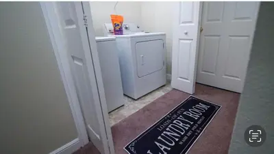 a bathroom with a washer and dryer and a sign on the floor at Stylish and cozy townhome! in Orlando