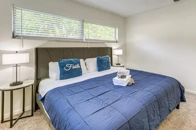 a bedroom with a large bed with blue sheets and blue pillows at Gateway to Orlando Theme Parks! Home with Large Yard in Orlando