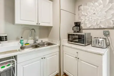 a kitchen with white cabinets and a sink and a microwave at Townhome with Fenced Yard in Orlando Suburbs! in Orlando