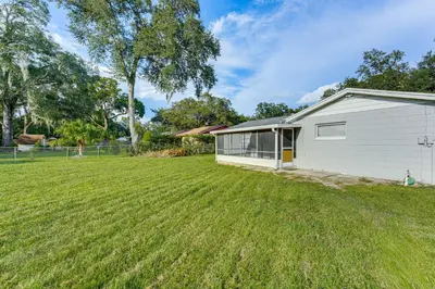 a house with a large yard in front of it at Townhome with Fenced Yard in Orlando Suburbs! in Orlando