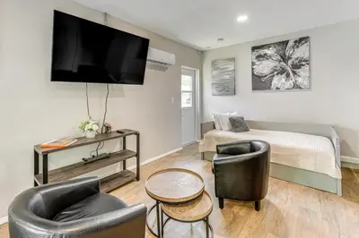 a bedroom with a bed and two chairs and a television at Townhome with Fenced Yard in Orlando Suburbs! in Orlando