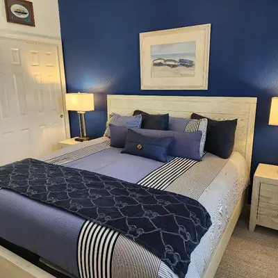 a bedroom with a large bed with blue walls at Mickeys Magical Escape in Orlando
