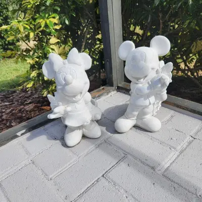 a couple of white figurines sitting on a porch at Mickeys Magical Escape in Orlando