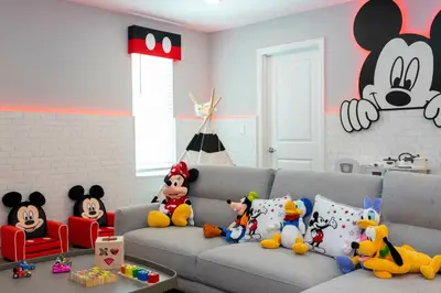 a living room with a gray couch with stuffed animals on it at Brand New 9 Bedroom Single Family Storey Lake 18ST in Kissimmee