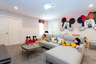a living room with mickey mouse decorations on the wall at Brand New 9 Bedroom Single Family Storey Lake 18ST in Kissimmee