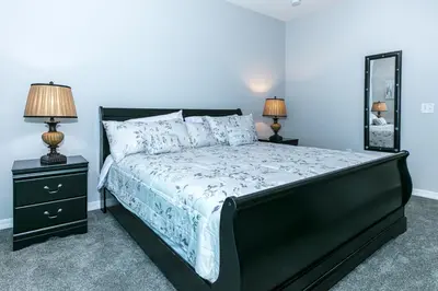 a bedroom with a bed and two lamps and a mirror at Comfy and Spacious House in Kissimmee