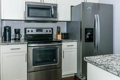 a kitchen with a stove and a stainless steel refrigerator at Comfy and Spacious House in Kissimmee