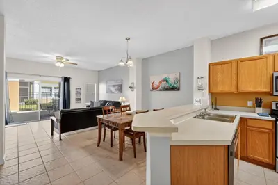 a kitchen and living room with a table and a dining room at Modern Kissimmee Townhouse near Disney townhouse in Kissimmee