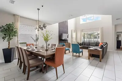 a dining room and living room with a table and chairs at Casa 5Q c/ Piscina Sul e Game Room – Storey Lake in Kissimmee