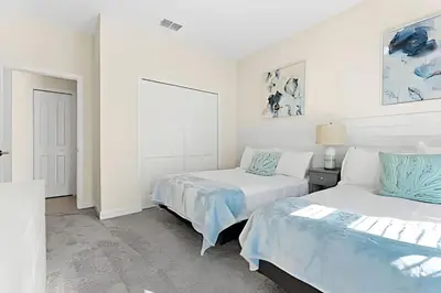 two beds in a room with white walls at Casa 6Q c/ Piscina & Quartos Temáticos in Kissimmee